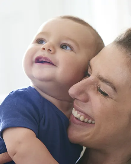 Medela - woman holding baby and both are smiling.